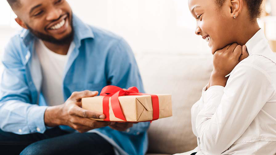 A father gives a gift to his daughter.