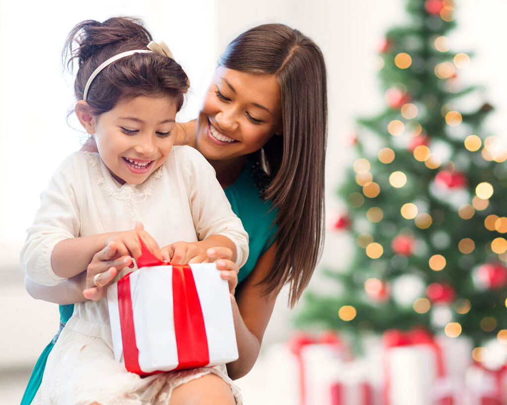 A woman and a child open a present together. 